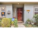 Inviting front entrance with a solid wood door, decorative features, and manicured shrubbery at 7925 Brown Bark Pl, Raleigh, NC 27615