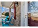 Inviting front porch with brick facade and blue Adirondack chairs, creating a cozy entrance at 80 Ingle View Ct, Burlington, NC 27215