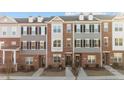 Charming townhome exterior featuring brick and gray siding, multiple windows, and well-maintained landscaping at 978 Gateway Commons Cir, Wake Forest, NC 27587