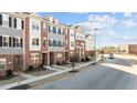 Exterior view of well-maintained townhomes with brick and siding, along a street with sidewalks and landscaping at 978 Gateway Commons Cir, Wake Forest, NC 27587