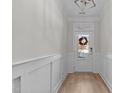 Bright foyer with hardwood floors and white wainscoting leading to the front door at 978 Gateway Commons Cir, Wake Forest, NC 27587