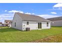 Spacious backyard featuring green grass, vinyl siding, and a sliding glass door for easy indoor-outdoor living at 103 Flue Ct, Oxford, NC 27565