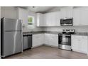 A modern kitchen boasts stainless steel appliances, granite countertops, and pristine white cabinetry at 103 Flue Ct, Oxford, NC 27565