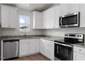 A modern kitchen boasts stainless steel appliances, granite countertops, and pristine white cabinetry at 103 Flue Ct, Oxford, NC 27565
