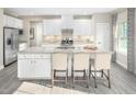 Bright, modern kitchen with white cabinets, a large center island, and stainless steel appliances at 1032 Country Pasture Cv, Wendell, NC 27591