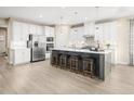 Large kitchen with white cabinets, stainless steel appliances, central island and bar stool seating at 1032 Country Pasture Cv, Wendell, NC 27591