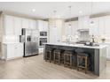 Spacious kitchen with white cabinetry, stainless steel appliances, a center island, and four bar stools at 1032 Country Pasture Cv, Wendell, NC 27591