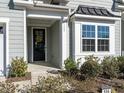 Close-up of a charming front entrance, featuring a black front door with a decorative wreath and sidelight window at 106 Ivory Ln, Raleigh, NC 27610
