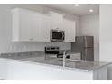 Modern kitchen with granite countertops, stainless steel appliances, and white cabinets at 107 Scoville St, Oxford, NC 27565