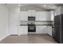 Bright kitchen boasts stainless steel appliances, white cabinets, and granite countertops at 108 Hybrid St, Oxford, NC 27565
