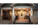 Inviting front porch with cozy seating, wreath on the door, and brick accents at 112 Rawhide Dr, Louisburg, NC 27549