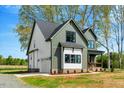 Side view of craftsman style home, showcasing the garage, yard, and black framed windows at 1403 Antioch Church Rd, Timberlake, NC 27583