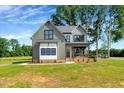 Beautiful two-story home with a covered front porch and manicured lawn on a sunny day at 1403 Antioch Church Rd, Timberlake, NC 27583