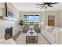 Inviting living room with fireplace, stylish furniture, large windows offering scenic views, and an elegant ceiling fan at 1403 Antioch Church Rd, Timberlake, NC 27583