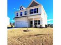 Beautiful two-story home featuring a two car garage, well-maintained lawn, and a bright, sunny sky at 265 Forest Meadow Ln, Franklinton, NC 27525