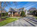 Beautifully landscaped two-story home with a stone facade, driveway, and charming backyard fence and arbor at 2920 Claremont Rd, Raleigh, NC 27608