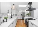 Modern kitchen featuring sleek white cabinetry, stainless steel appliances, and eye-catching geometric backsplash at 330 Wesley Dr, Chapel Hill, NC 27516