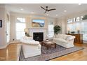 Bright living room features fireplace, ceiling fan and large windows providing natural light at 3937 Bentley Brook Dr, Raleigh, NC 27612