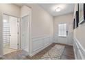 Inviting entry way with wainscoting detail and wood-look floors leading to a bathroom and front door at 4888 Pioneer Dr, Sanford, NC 27330