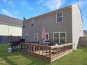 Spacious backyard with a wooden deck, grill, well-maintained lawn, and privacy fencing at 5321 Carnelian Dr, Raleigh, NC 27610