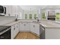 Modern kitchen with white cabinets, granite countertops, stainless steel appliances, and natural light at 5945 Four Townes Ln, Raleigh, NC 27616