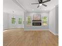Bright living room with hardwood floors, a modern fireplace, and large windows offering scenic views at 5945 Four Townes Ln, Raleigh, NC 27616