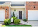 Inviting front entrance with a decorative wreath on a black door, landscaping, and a 'Welcome' sign at 622 Village Lake Drive, Mebane, NC 27302