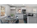 Modern kitchen features sleek appliances, granite counters, stylish backsplash and a glass dining table at 838 Waring St, Durham, NC 27704