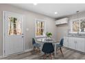 Eat-in kitchen features white cabinetry, stainless steel appliances, and a glass top dining table at 838 Waring St, Durham, NC 27704
