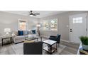 Cozy living room with neutral walls and hardwood flooring offers ample natural light and ceiling fan at 838 Waring St, Durham, NC 27704
