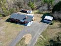 Aerial view of a brick home with a detached garage and curved driveway surrounded by greenery at 8604 N Roxboro St, Bahama, NC 27503