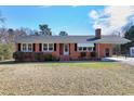 A cozy brick home with classic white-trimmed windows and tidy landscaping on a sunny day at 8604 N Roxboro St, Bahama, NC 27503
