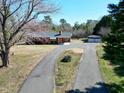 A single-story brick home featuring a detached garage, set back from a curved driveway at 8604 N Roxboro St, Bahama, NC 27503