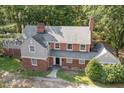 Lovely aerial view of a traditional brick home with a lush, green backyard and mature trees surrounding the property at 938 Hargrove St, Henderson, NC 27536