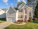 Traditional two-story home boasting an attached garage, complemented by a neatly landscaped yard and charming architectural details at 1006 Scotsburg Trl, Hillsborough, NC 27278
