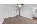 Neutral bedroom featuring a ceiling fan, closet, and doorway leading to the en-suite bathroom at 101 Wimbledon Ct, Clayton, NC 27520