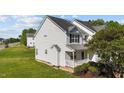 Side view of a charming two-story house featuring white siding and a well-manicured lawn at 101 Wimbledon Ct, Clayton, NC 27520