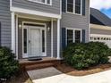 Inviting front entrance with brick steps, white columns, and decorative lighting at 103 Glenstone Ln, Cary, NC 27518