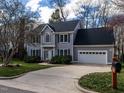 Two-story home with an attached two car garage, blue shutters, and established landscaping at 103 Glenstone Ln, Cary, NC 27518
