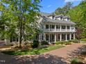 Inviting home with a brick driveway, a spacious front yard, lush landscaping, and a welcoming front porch at 109 Chimeneas Pl, Chapel Hill, NC 27517