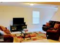Inviting living room featuring cozy sofas, a modern TV stand, and a stylish glass coffee table at 1141 Early Rise St, Raleigh, NC 27610