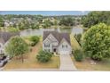 Beautiful home overlooking a serene lake, surrounded by lush greenery and mature trees at 121 Stone Nut Trl, Fuquay Varina, NC 27526
