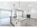 Open-concept kitchen with a large island, stainless steel appliances, and views of the living room with a fireplace at 123 Pretty Run Branch Ln, Wendell, NC 27591