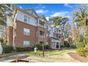 Exterior view of multi-story brick and siding condo complex with manicured lawn at 1700 Tiffany Bay Ct # 303, Raleigh, NC 27609