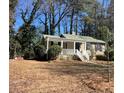 Single story home featuring a cozy front porch and mature trees in the yard at 1704 Delaware Ave, Durham, NC 27705