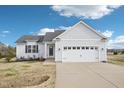 Charming white exterior of a two-story home with a two-car garage at 174 Arrow Ln, Middlesex, NC 27557