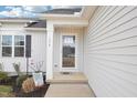 A welcoming front entryway with glass door and a small covered porch area with pleasant landscaping at 174 Arrow Ln, Middlesex, NC 27557
