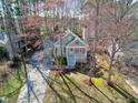 An aerial view of a light blue house surrounded by trees with vibrant pink blossoms at 1821 Kelly Glen Dr, Apex, NC 27502