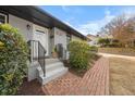 Welcoming entrance with brick path, freshly painted gray walls, and a tidy, landscaped garden at 1917 Bivins St, Durham, NC 27707