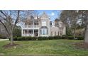 Beautiful home featuring a covered front porch, bay windows, shutters, and lush green lawn, offering a serene living environment at 318 Belles Landing Ct, Cary, NC 27519